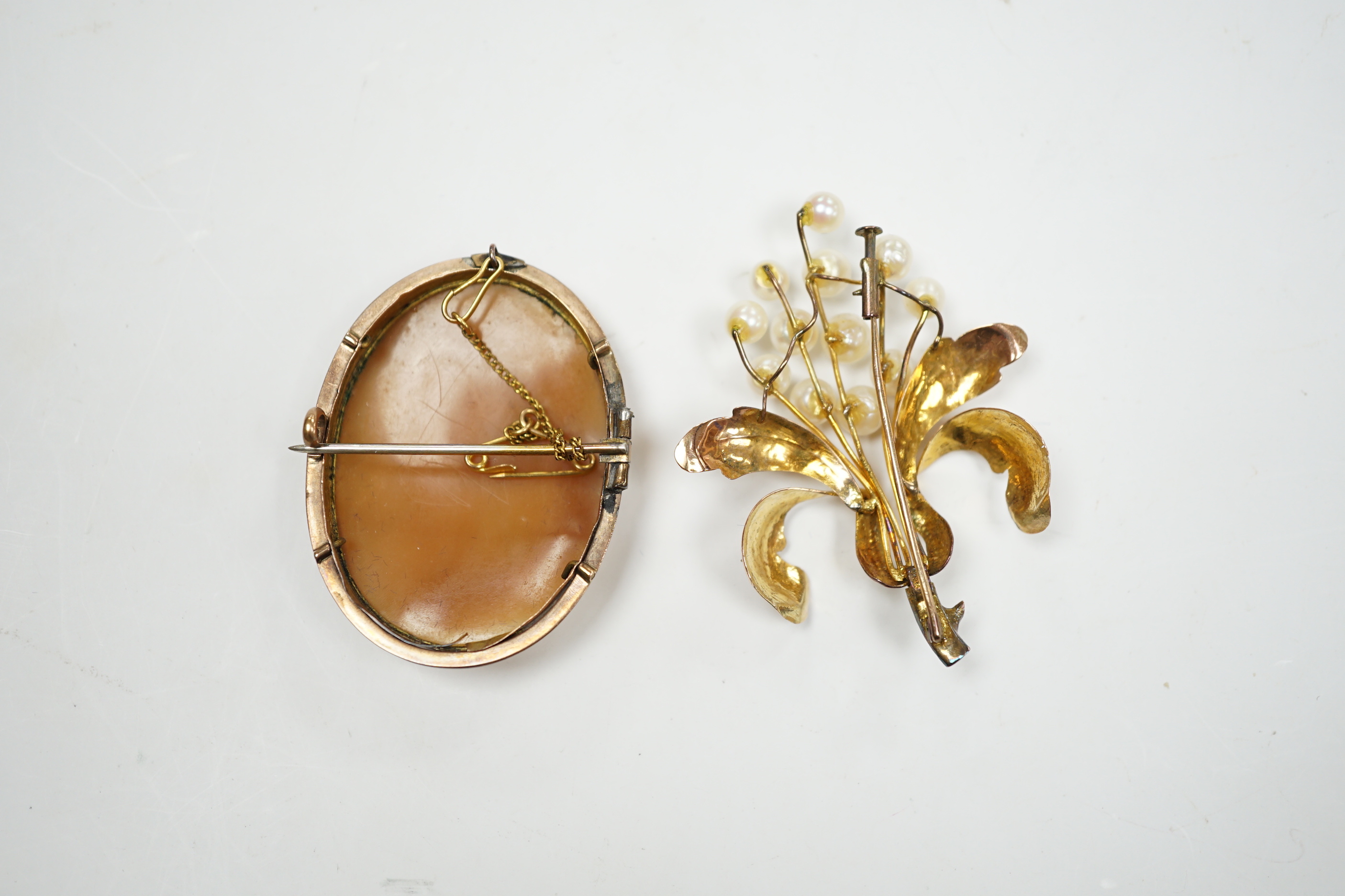 A 14K yellow metal and cultured pearl cluster set floral brooch, 52mm, gross weight 7 grams, together with a yellow metal mounted carved cameo shell brooch.